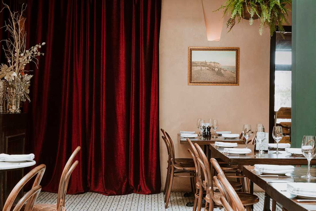 Aménagement d'un restaurant bistrot et tropical -  salle avec rideau de velours rouge